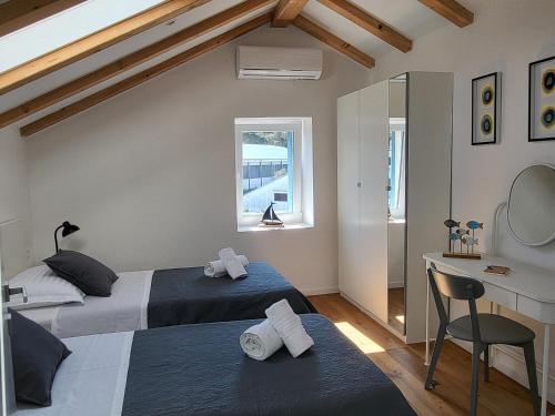 two beds in a bedroom with a desk and a chair at Casa Solis Losinj in Mali Lošinj