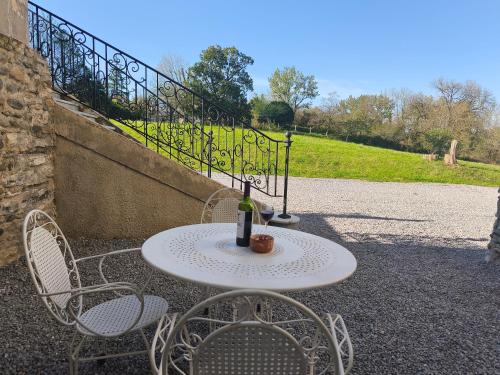 a table with a bottle of wine and two chairs at ChâtEscos - Estudio en Château in Escos
