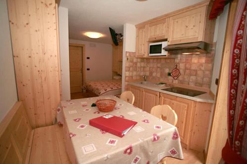 eine Küche mit einem Tisch und einem Tischtuch darauf in der Unterkunft Appartamenti Albert in Canazei