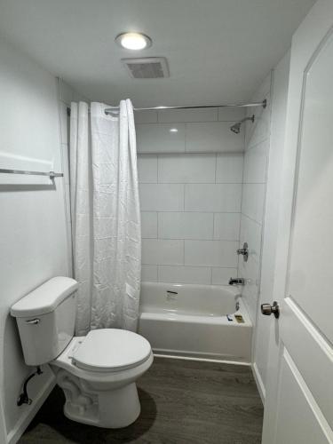 a bathroom with a toilet and a bath tub at Angel's Motel near Anaheim in Orange