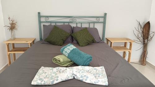 a bed with two pillows and a blanket on it at Ka'Zinha Guesthouse - Chambres d'hôtes Tarrafal in Tarrafal