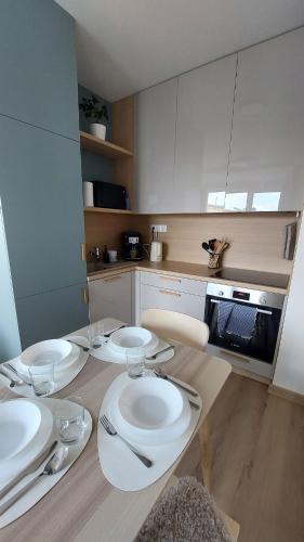 a kitchen with four white plates on a table at Apt 415 Svit in Jezersko