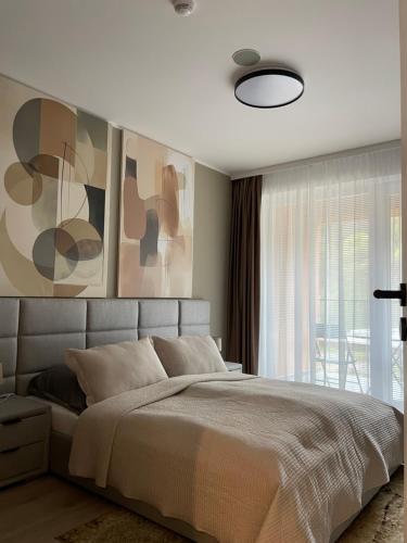 a bedroom with a large bed and a large window at Apartmán beige Bardejovské Kúpele in Bardejov