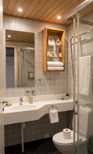 a bathroom with a sink and a toilet and a mirror at Tiera Resort in Taivalkoski