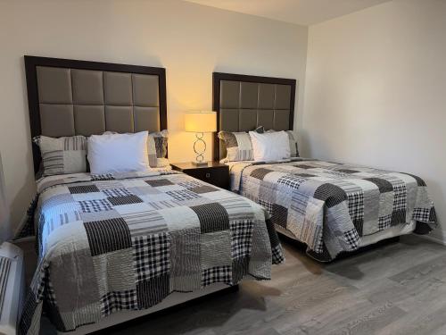 two beds sitting next to each other in a bedroom at Knights Inn London Ontario in London