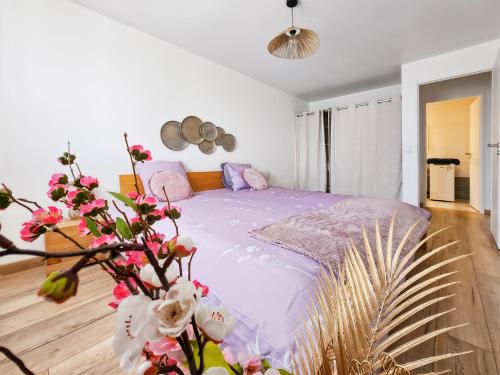a bedroom with a bed with purple sheets and flowers at Maison Familiale, Jardin Privé, Proche Disneyland in Coutevroult