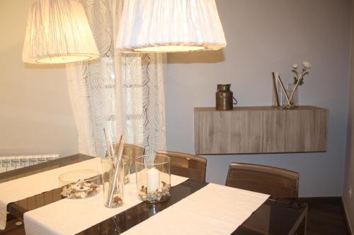 a dining room with a table with chairs and lights at Cal Arxè in Besalú