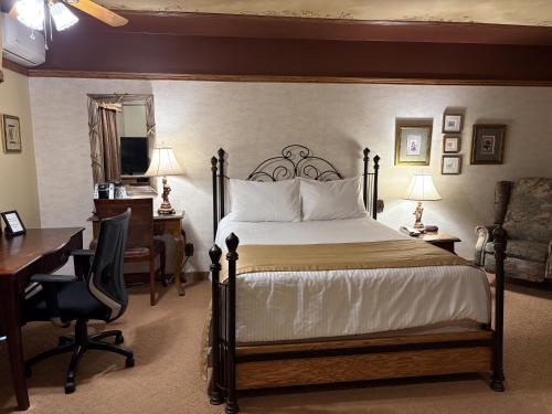 a hotel room with a bed and a desk and a desk at Motel Grand-Pré Inc in Bonaventure