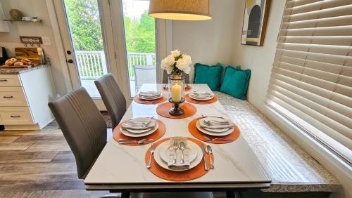 a dining room table with plates and utensils on it at 4 BR - King beds - perfect for HPU, Furniture Market, Greensboro, Winston in High Point