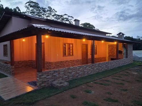 a house with a porch and lights on it at Cottage Saint Antoine in Pedra Azul