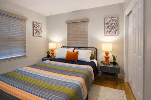 a bedroom with a bed with two lamps and a window at 4 BR - King beds - perfect for HPU, Furniture Market, Greensboro, Winston in High Point