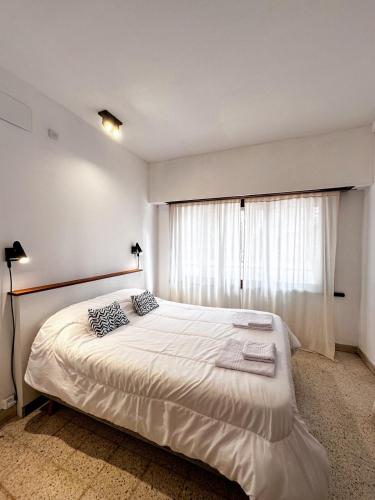 a bedroom with a large white bed and a window at Casa amplia, céntrica y con garage en Junin, BA in Junín