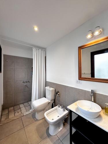 a bathroom with a toilet and a sink and a mirror at Casa amplia, céntrica y con garage en Junin, BA in Junín