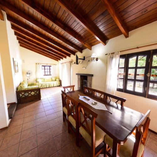 a dining room with a wooden table and chairs at Pinar del Arroyito in Villa General Belgrano