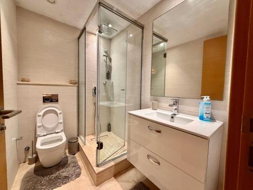 a bathroom with a toilet and a shower and a sink at Modern and cozy CFC apartment in Casablanca