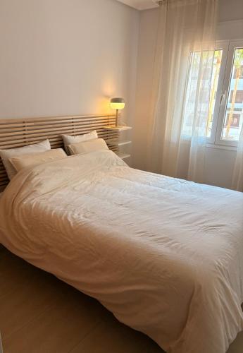 a large white bed in a bedroom with a window at Casa Sol Serena - Pool, Beach & Golf in Los Alcázares