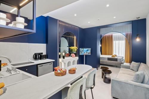 a kitchen and living room with blue walls at FatCow Residences in Larnaca