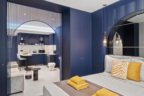 a bedroom with blue walls and a bed with yellow pillows at FatCow Suites City Centre in Larnaca