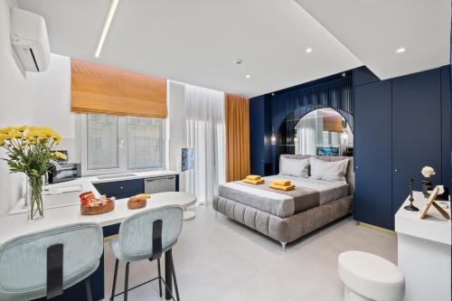 a bedroom with a bed and a table and chairs at FatCow Suites City Centre in Larnaca
