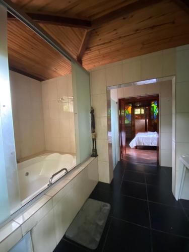 a bathroom with a bath tub and a bedroom at Pousada e Camping Lumiar in Lençóis