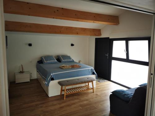 a bedroom with a blue bed and a couch at "La Parenthèse balarucoise" in Balaruc-le-Vieux