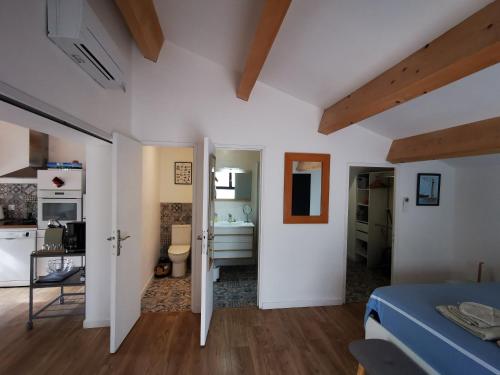 a white room with a bed and a bathroom at "La Parenthèse balarucoise" in Balaruc-le-Vieux