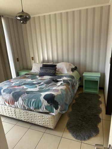 a bedroom with a bed and a rug at A pasos de cavancha in Iquique