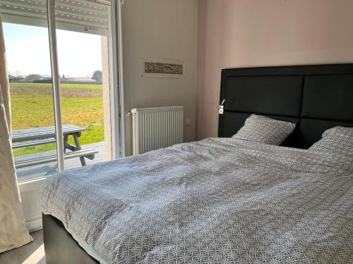a bedroom with a large bed and a window at Maison de plain pied in Certines