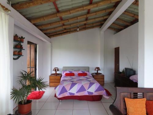 a bedroom with a bed and a wooden ceiling at Nebraska's Corner cerca de aeropuerto de Tababela in Yaruguí
