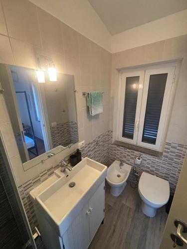 a bathroom with a sink and a toilet at Stella Sea House2 in Torvaianica