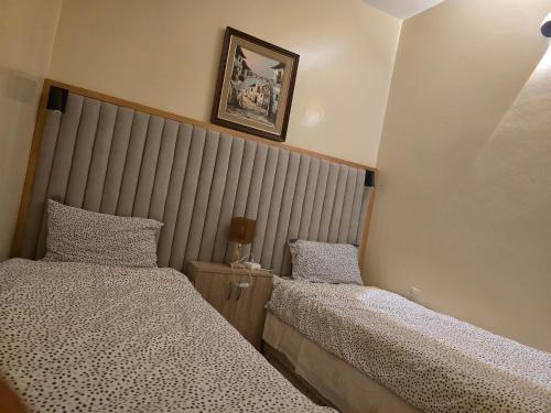 a bedroom with two beds and a headboard at Appartement familial شقة للعائلة in Meknès