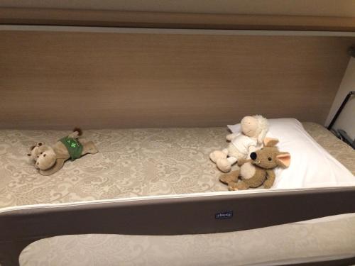 three stuffed animals sitting on top of a bed at Point Cardinal in Geneva