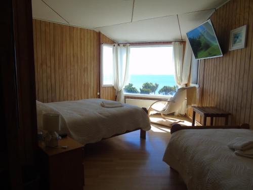 a hotel room with two beds and a window at Complejo Turistico Arena Gruesa in Ancud