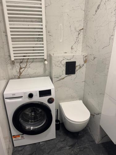 a bathroom with a washing machine and a toilet at Amazing Studio Close to Oldtown in Gdańsk