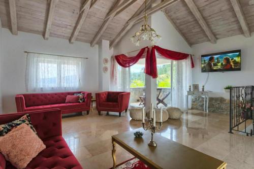 a living room with red couches and a table at Villa Lapis with Private Pool in Buzet