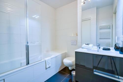 a white bathroom with a toilet and a shower at Gorgeous duplex near top attractions in Saint-Ouen