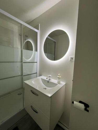 a white bathroom with a sink and a mirror at Love appart Parisienne in Villeneuve-Saint-Georges