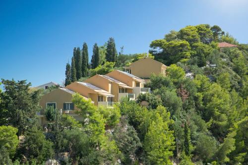 a house on the side of a hill with trees at Ionian Vista Villas in Argostoli