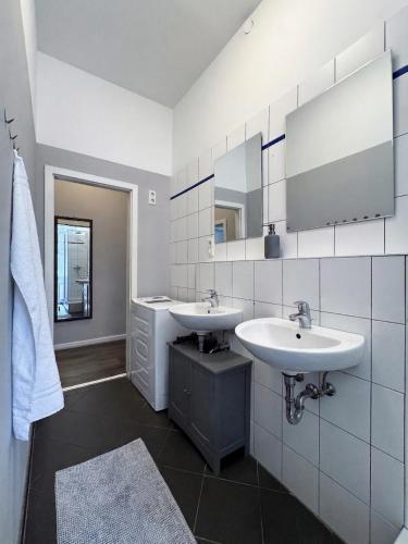 a bathroom with two sinks and a mirror at City-Apartment Schöneweide in Berlin