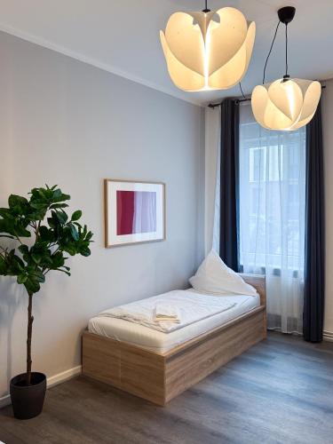 a bedroom with a bed and a potted plant at City-Apartment Schöneweide in Berlin