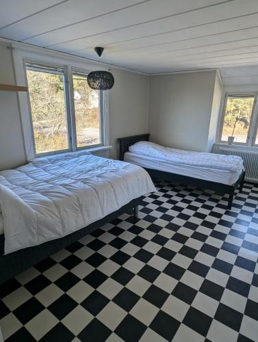 a bedroom with two beds and a checkered floor at Steneryd Salongen in Karlskrona