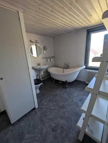 a bathroom with a tub and a toilet and a sink at Steneryd Salongen in Karlskrona