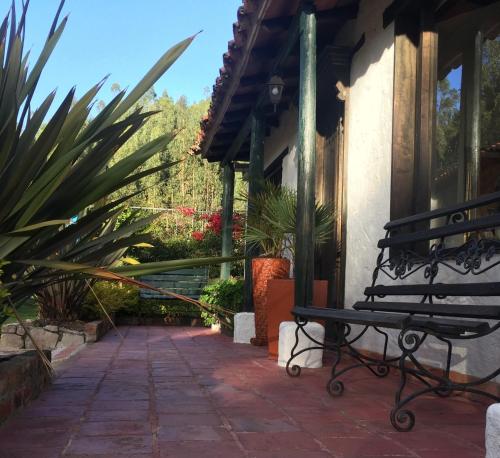 a bench sitting outside of a house with plants at San Mateo Hotel Campestre in Nobsa