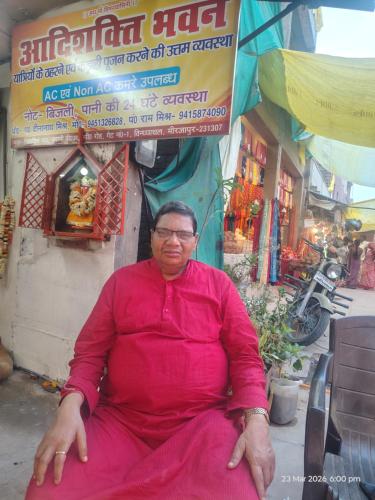 an older man sitting in front of a building at आदिशक्ति भवन in Mirzāpur
