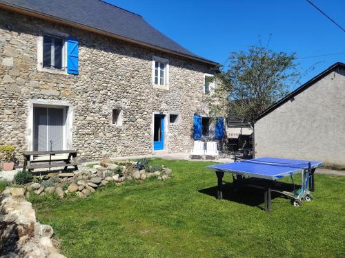 a ping pong table in front of a stone house at Les pierres qui parlent in Précilhon