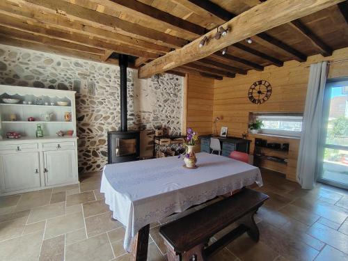 a dining room with a table and a clock on the wall at Les pierres qui parlent in Précilhon