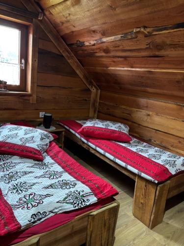 two beds in a room with wooden walls at Rancho-Bierna in Bierna
