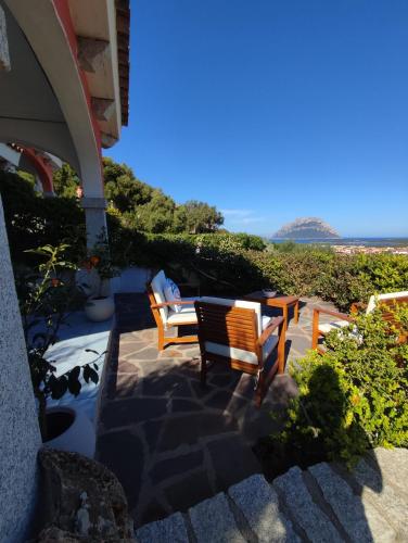 a patio with two chairs and a table at Villetta bifamiliare con vista mare "Poggio Tavolara" in Porto San Paolo