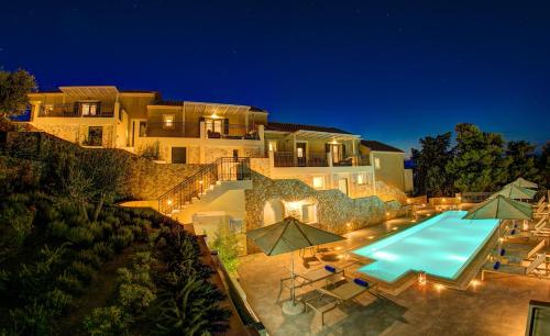 a large house with a swimming pool at night at Ionian Vista Villas in Argostoli