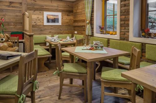 a restaurant with wooden tables and green chairs at Schönauerhof in Schlanitzen
